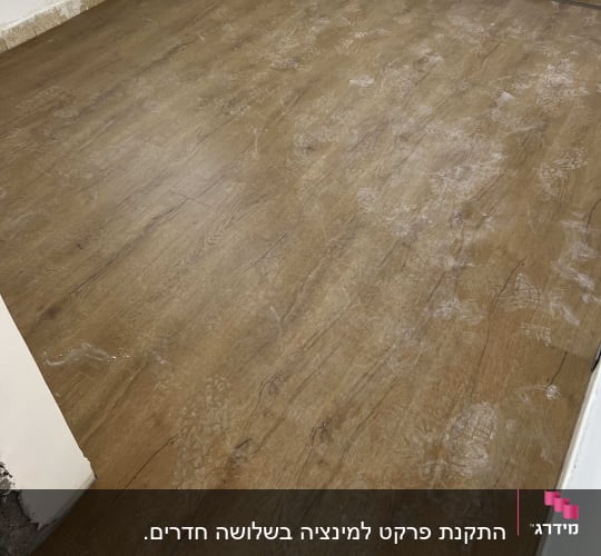 רצפת פרקט עץ עם סימני אבק וטביעות רגליים